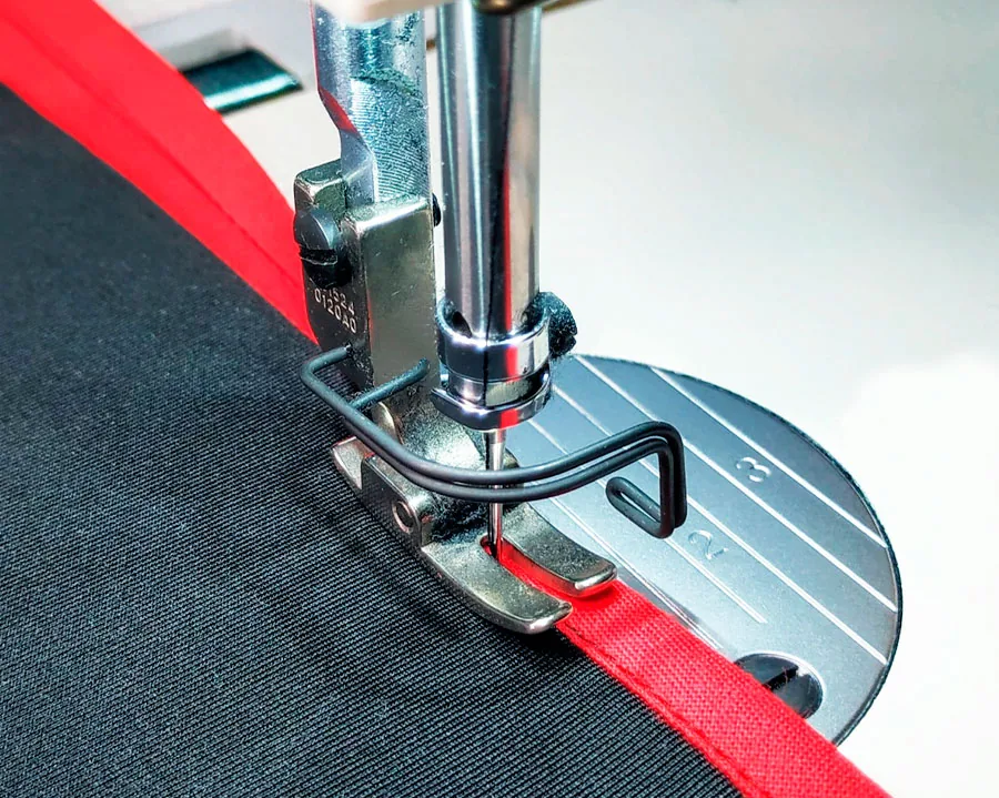 Máquina de coser aplicando cinta al bies